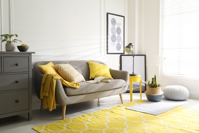 Stylish living room with sofa. Interior design in grey and yellow colors