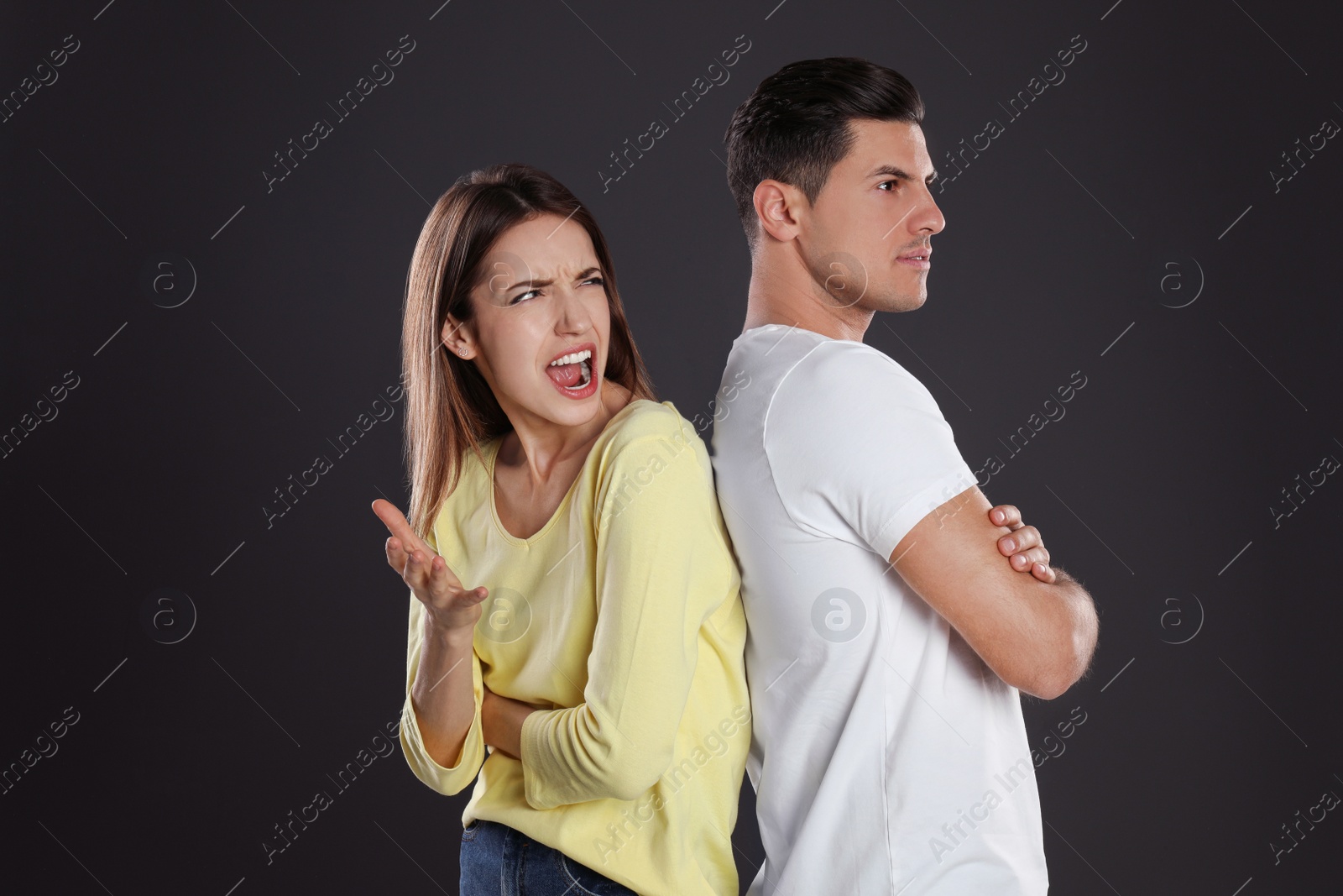 Photo of Woman shouting at her boyfriend on black background. Relationship problems