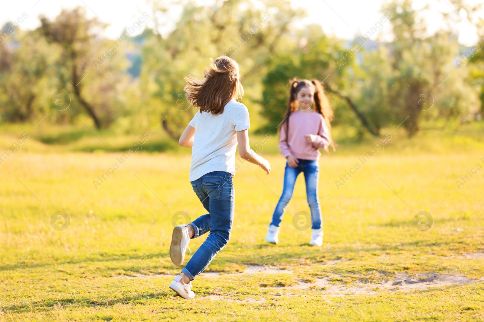 Photo of Cute little children playing together outdoors on sunny day