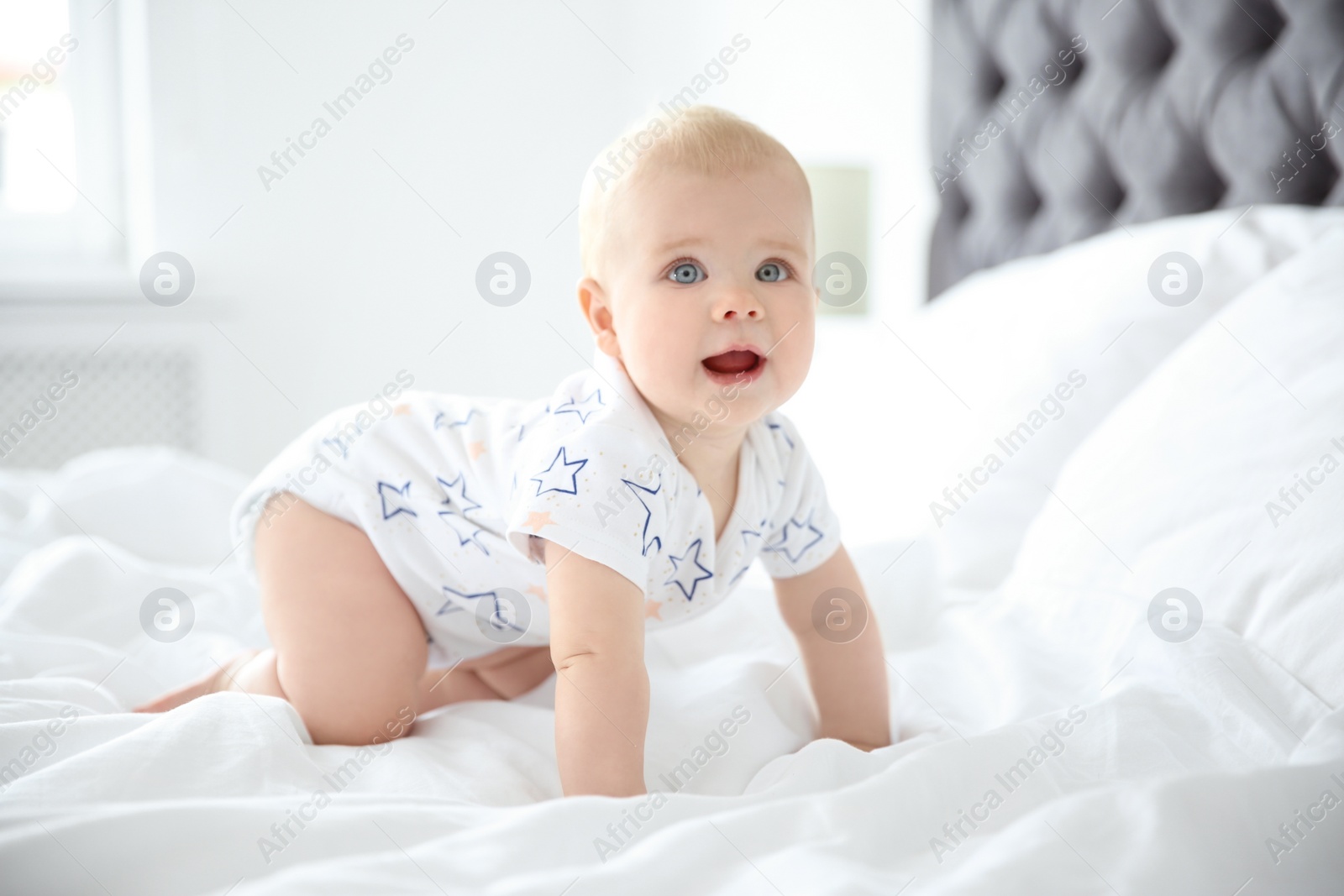 Photo of Cute little baby crawling on bed at home