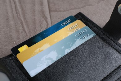 Credit cards in leather wallet on grey table, closeup