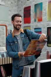 Young man with vinyl record in store