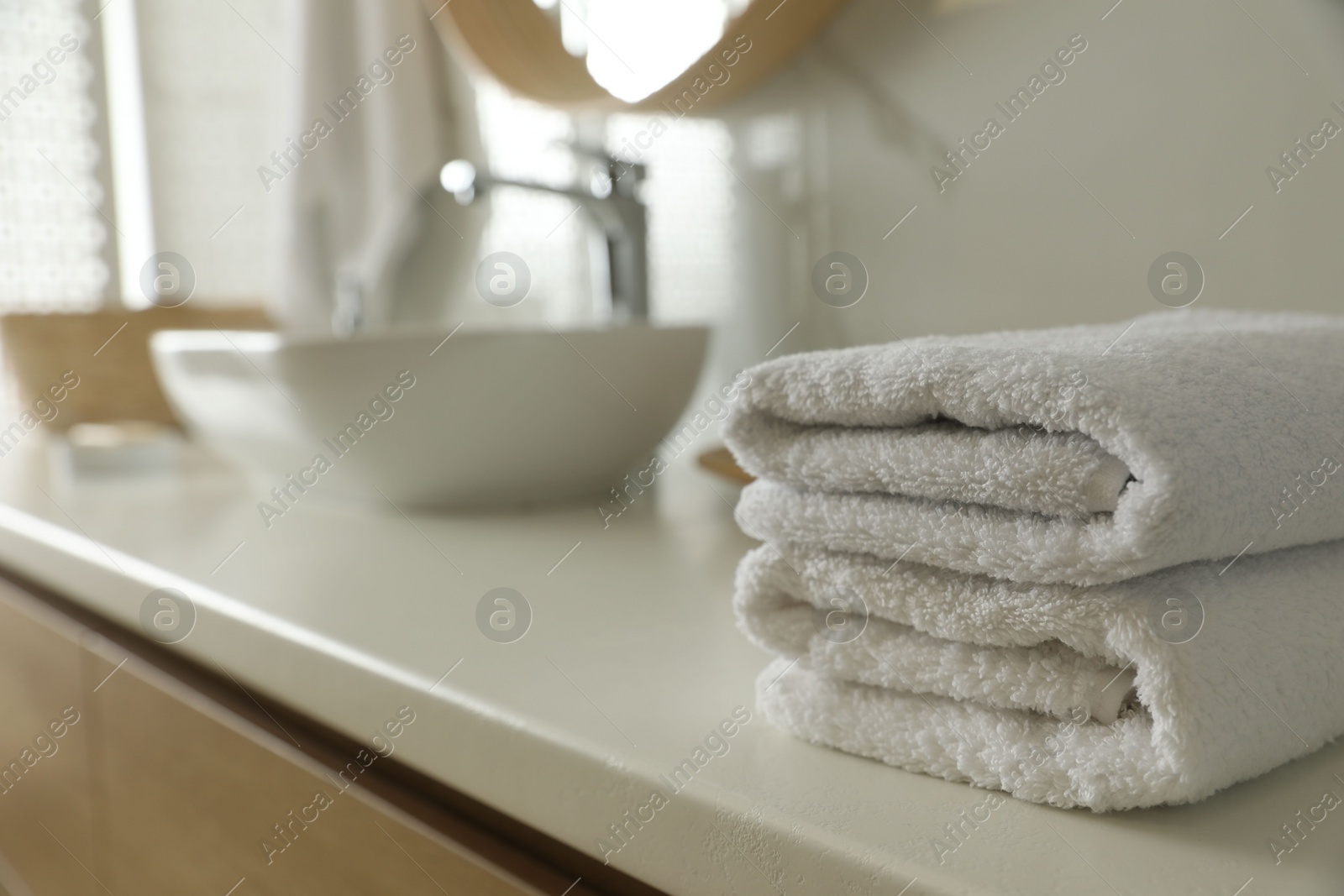 Photo of Stack of clean towels on countertop in bathroom. Space for text