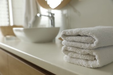 Stack of clean towels on countertop in bathroom. Space for text