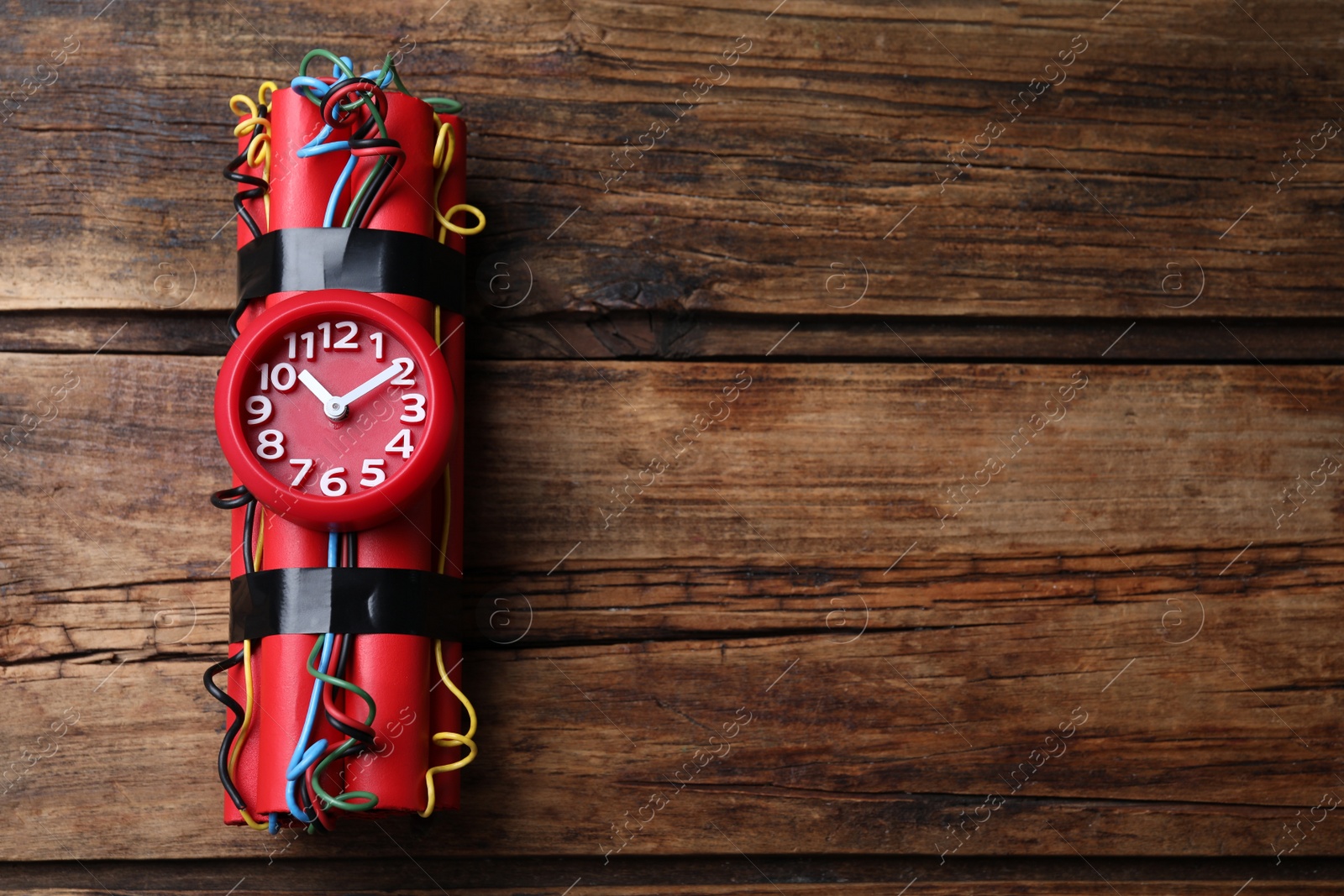 Photo of Dynamite time bomb on wooden table, top view. Space for text