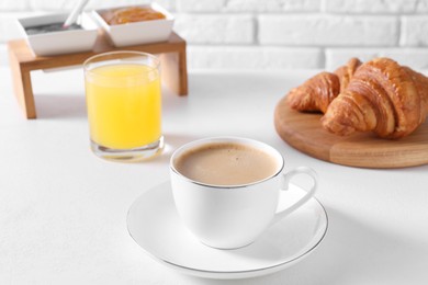 Photo of Fresh croissants and coffee on white table. Tasty breakfast