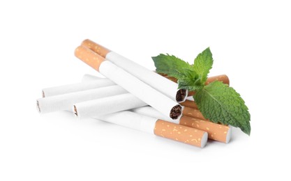 Photo of Menthol cigarettes and fresh mint leaves on white background