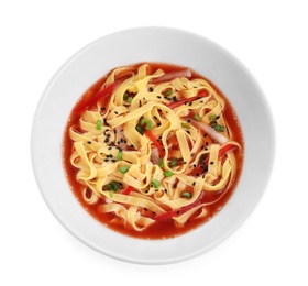 Plate of asian noodles with broth and vegetables isolated on white, top view