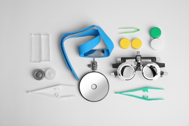 Photo of Different ophthalmologist tools on white background, flat lay