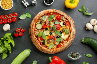 Photo of Flat lay composition with delicious hot vegetable pizza on black table