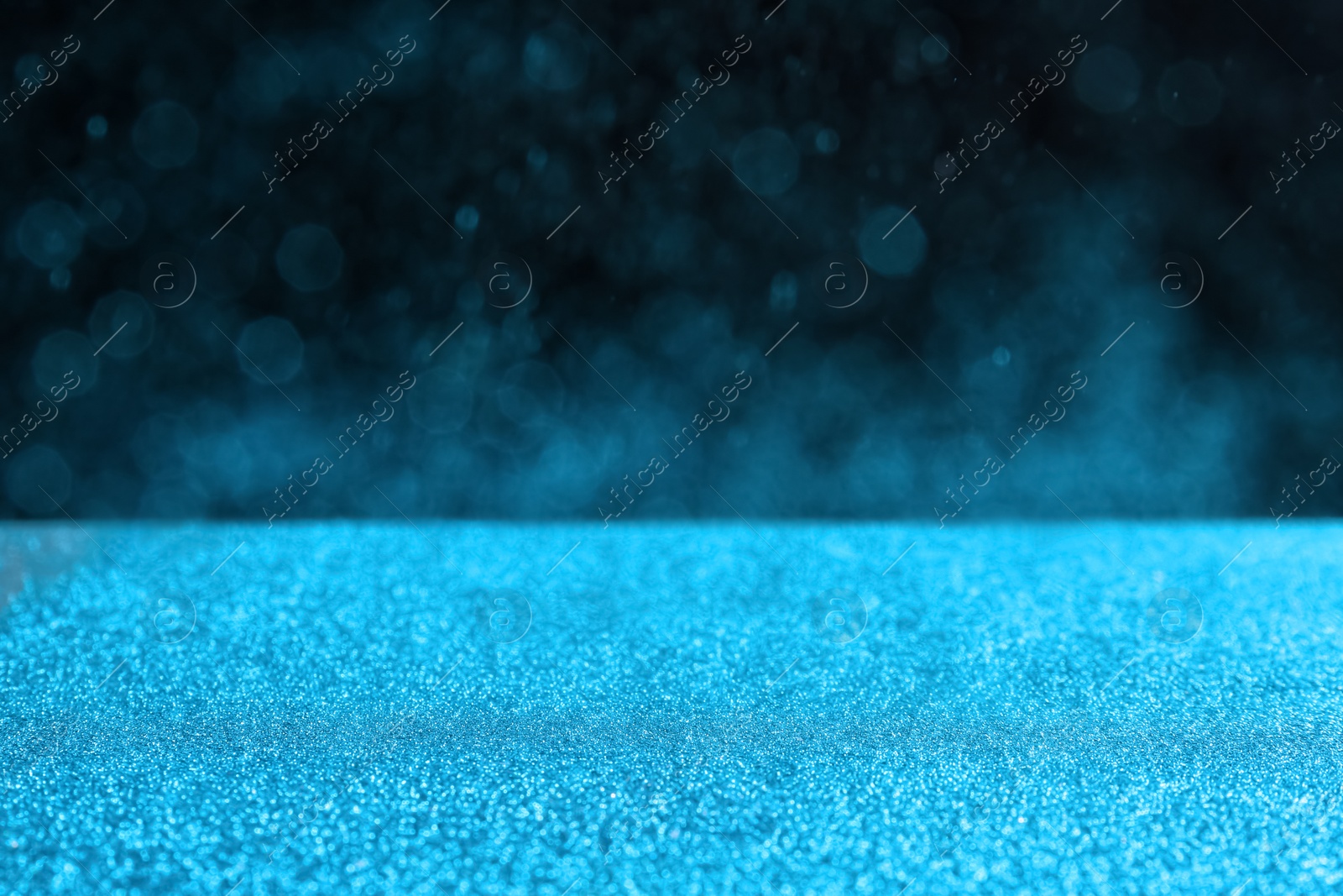 Photo of Glitter on table against dark background. Bokeh effect