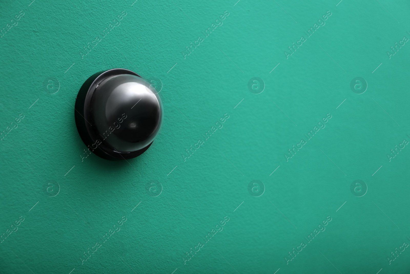 Photo of Modern CCTV security camera on green wall. Space for text