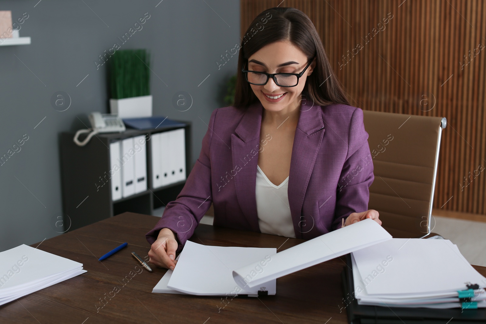 Photo of Beautiful businesswoman working with documents at table in office