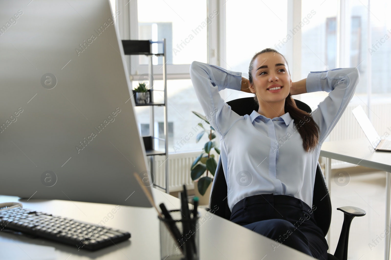 Photo of Young businesswoman relaxing in office chair at workplace