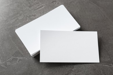 Blank business cards on grey table, above view. Mockup for design