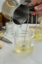Photo of Woman making candles at white table, closeup