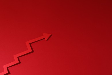 One zigzag paper arrow on red background, above view. Space for text