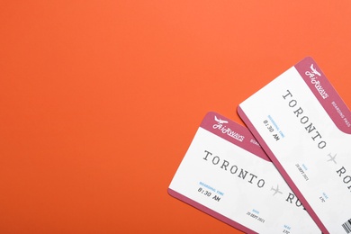 Photo of Avia tickets on orange background, flat lay with space for text. Travel agency concept