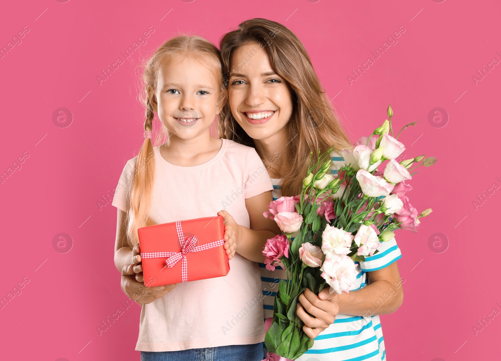 Photo of Little daughter congratulating her mom on pink background. Happy Mother's Day