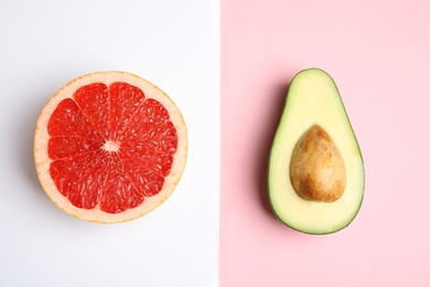 Cut ripe avocado and grapefruit on color background, flat lay