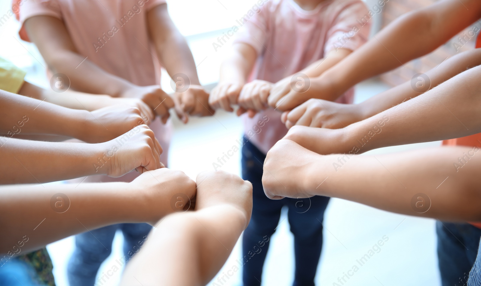 Photo of Little children putting their hands together, closeup. Unity concept