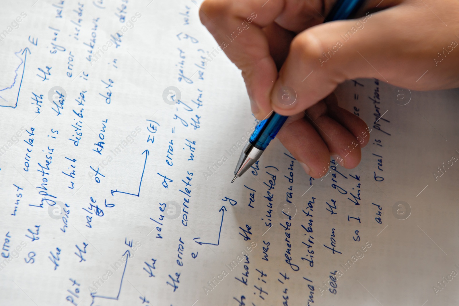 Photo of Student writing mathematical calculations on paper, closeup