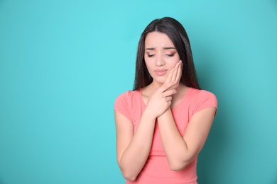 Photo of Woman with sensitive teeth on color background