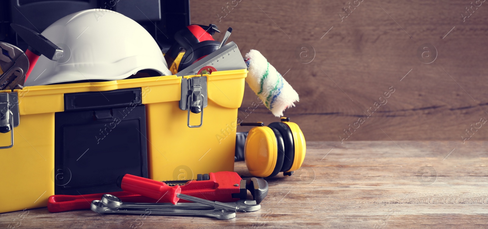 Image of Plastic box with construction tools on wooden table, space for text. Banner design