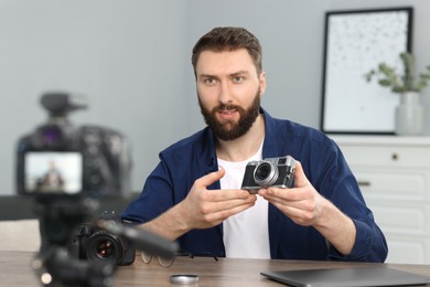 Photo of Technology blogger recording video review about cameras at home