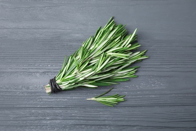 Bunch of fresh rosemary on color table, flat lay