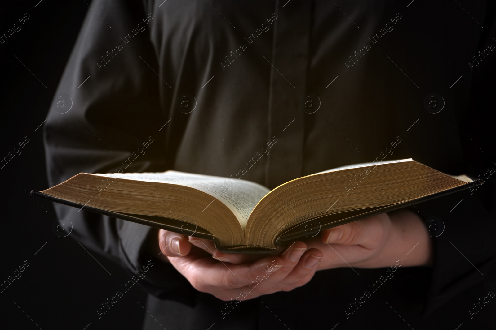 Photo of Woman reading holy Bible on black background, closeup