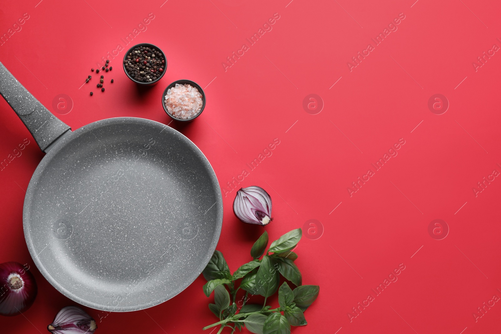 Photo of Flat lay composition with frying pan and fresh products on red background, space for text