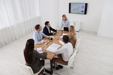 Photo of Businesswoman having meeting with her employees in office, above view