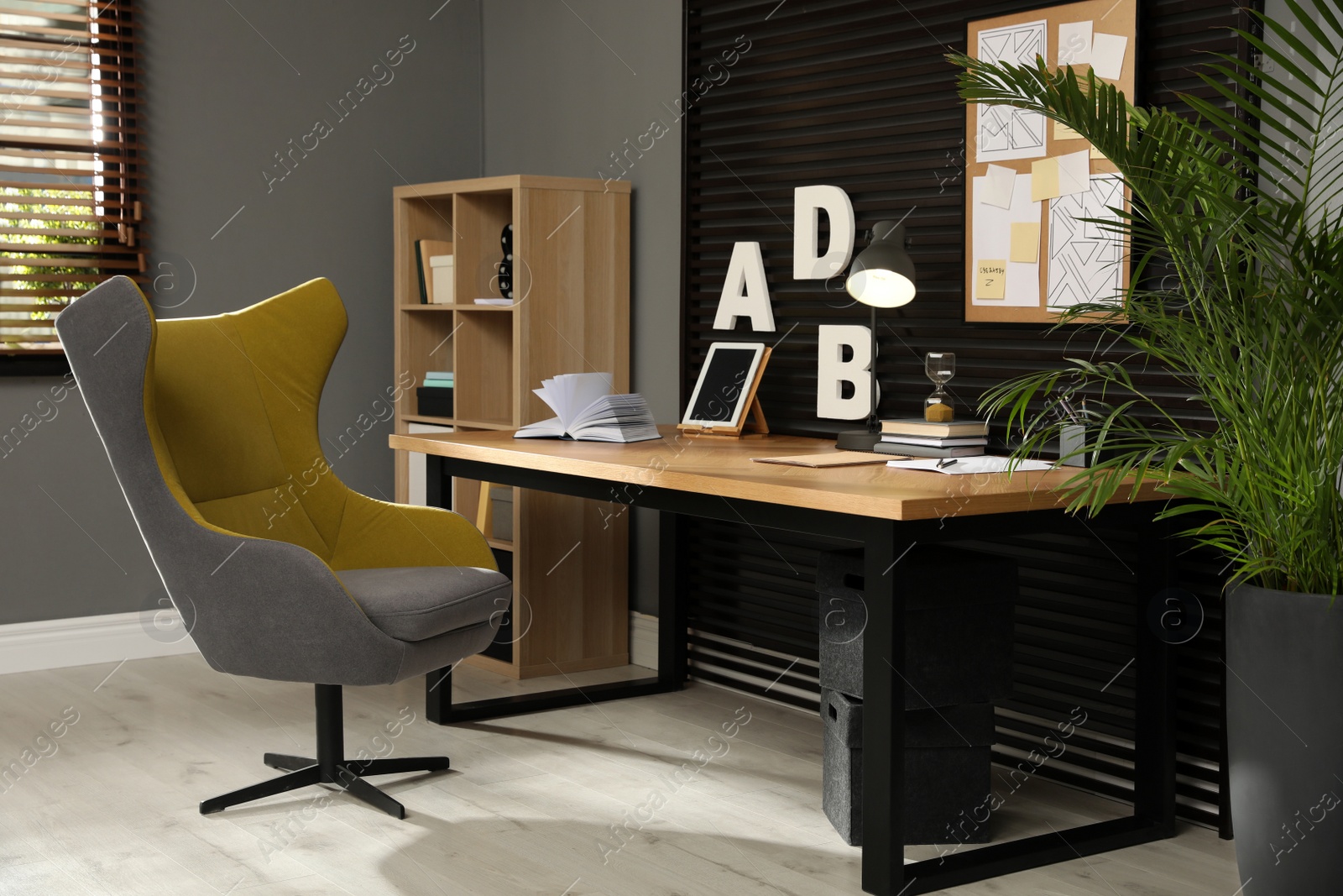 Photo of Comfortable workplace with wooden table and armchair