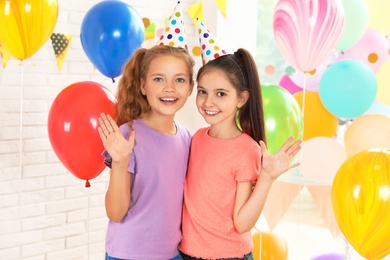 Photo of Happy children in room decorated for birthday party