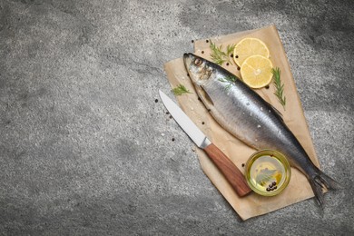 Photo of Delicious salted herring, olive oil, lemon and rosemary on grey table, top view. Space for text