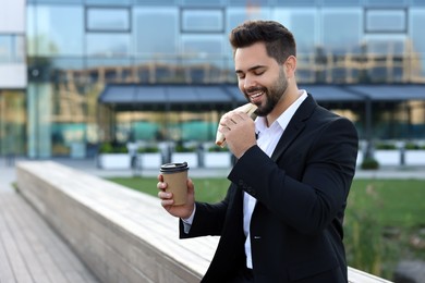 Photo of Smiling businessman having his lunch outdoors. Space for text