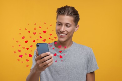 Long distance love. Man chatting with sweetheart via smartphone on golden background. Hearts flying out of device