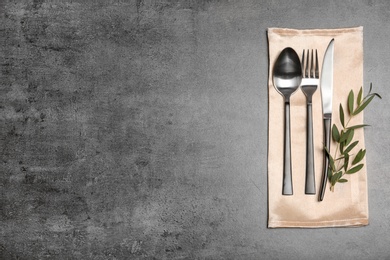 Photo of Cutlery and napkin on gray background, top view. Table setting