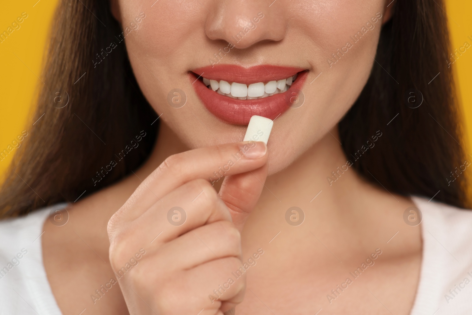 Photo of Woman with bubble gum on yellow background, closeup