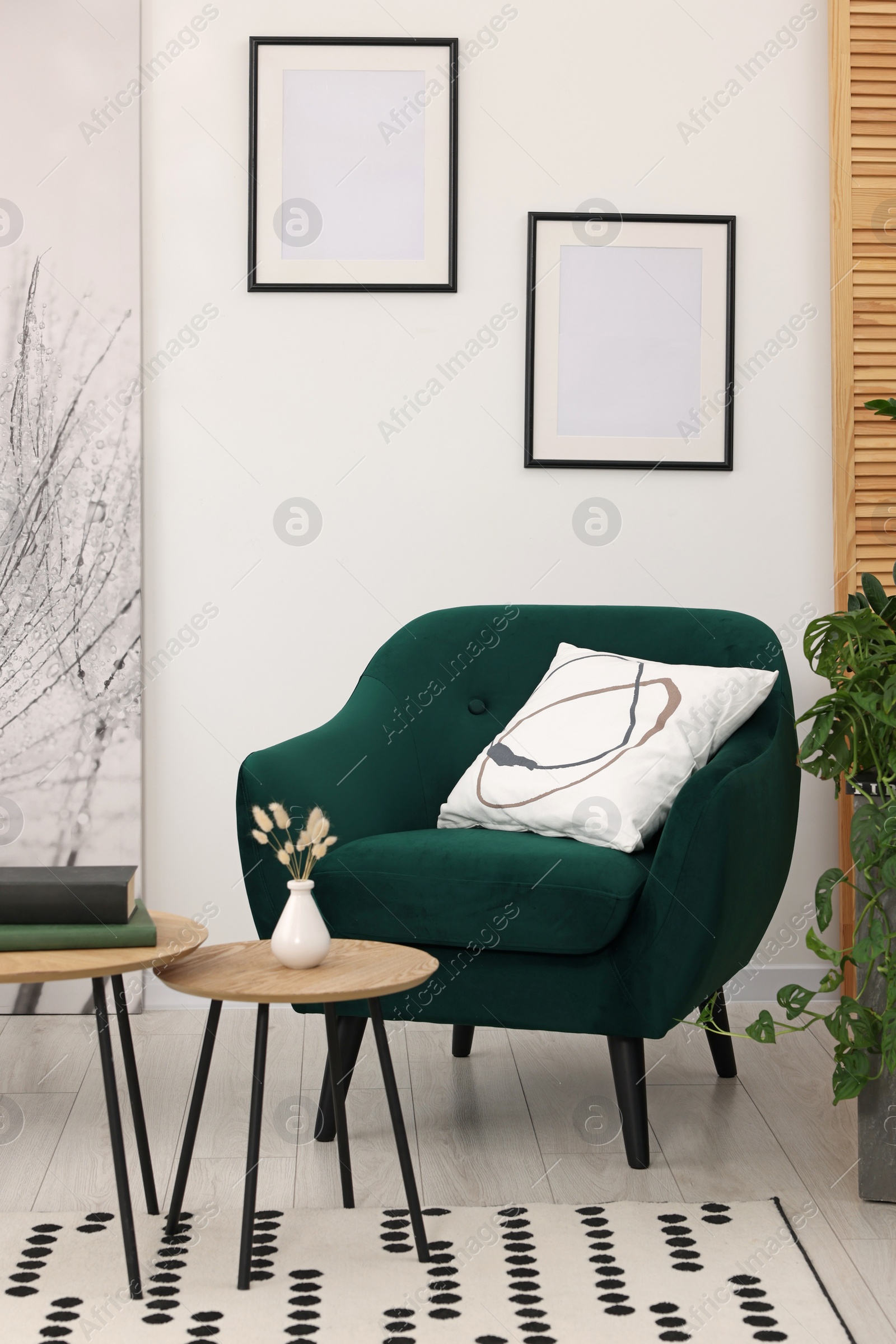 Photo of Comfortable armchair and nesting tables in stylish room