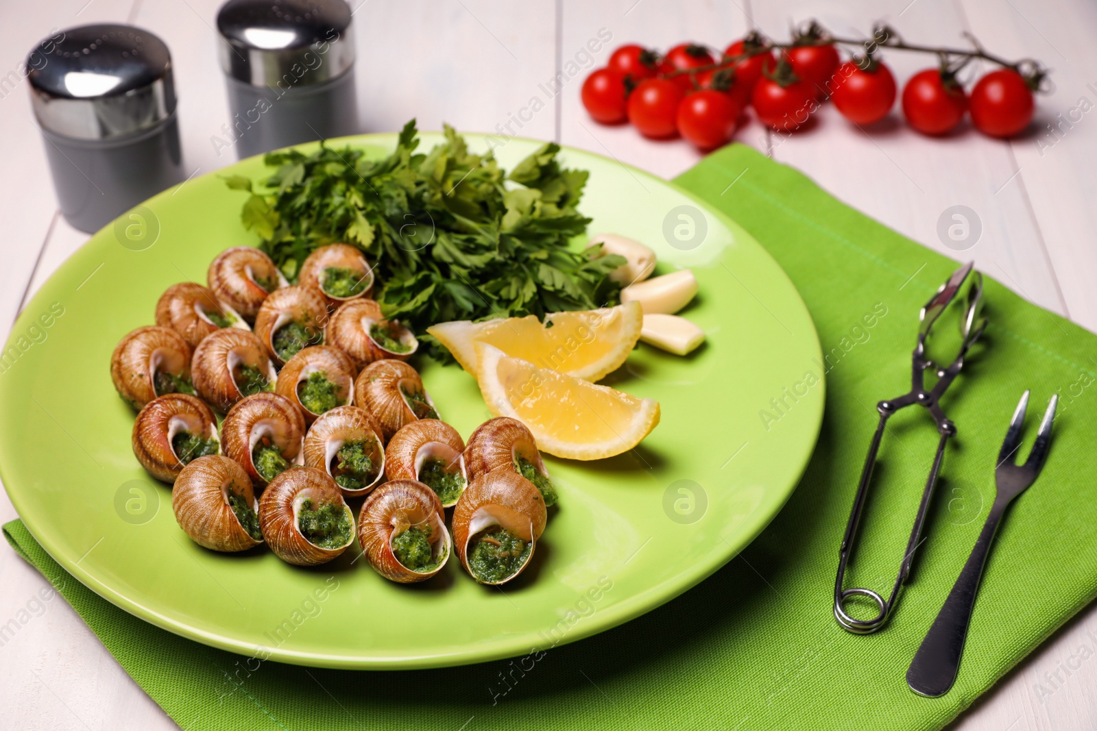Photo of Delicious cooked snails served on white table
