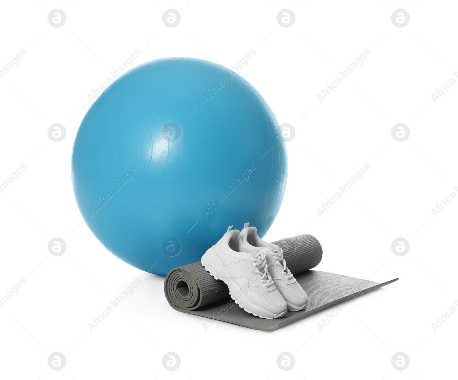 Photo of Fitness ball, sneakers and yoga mat isolated on white