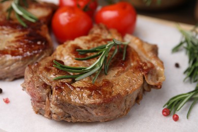Delicious fried meat with rosemary, tomatoes and spices on white table, closeup