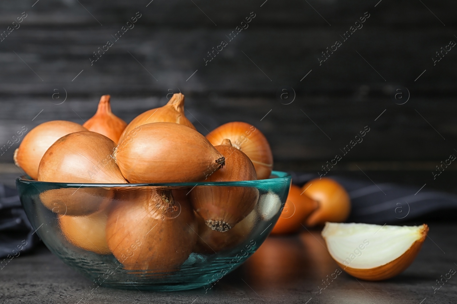 Photo of Bowl with fresh ripe onions on table