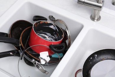 Photo of Messy pile of dirty kitchenware in sink, above view