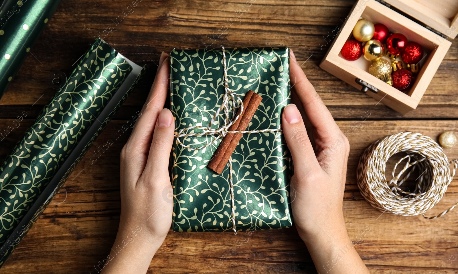 Photo of Woman with gift box at wooden table, top view