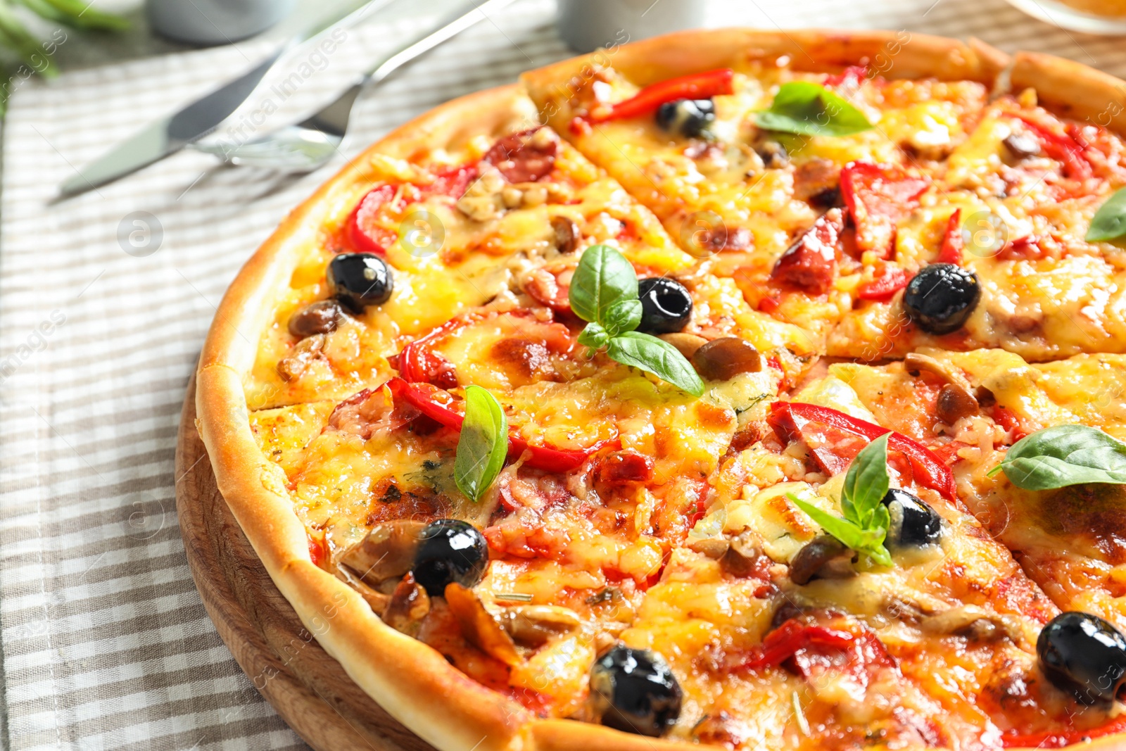 Photo of Delicious pizza with olives and sausages on table