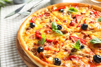 Photo of Delicious pizza with olives and sausages on table