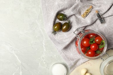 Pickling jar with fresh ripe cherry tomatoes and spices on grey table, flat lay. Space for text